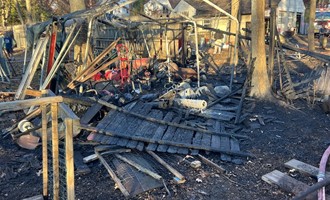 Orange brush fire chars woods, farm work area