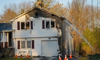 Bush Fire Extends to House in Newington